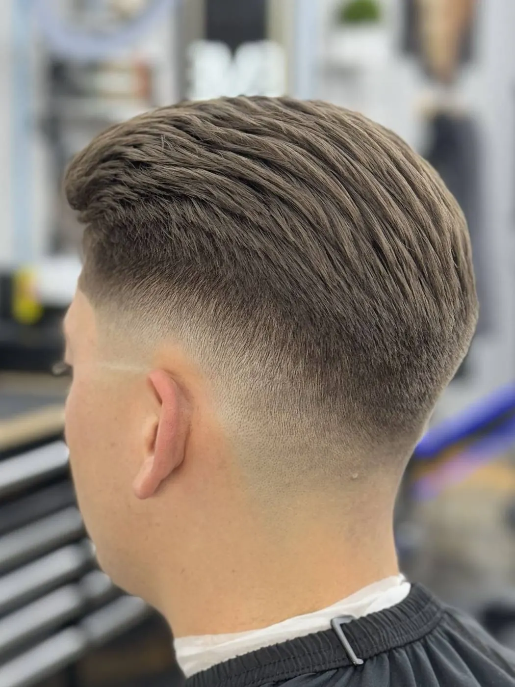 Slicked-back hair with a low fade